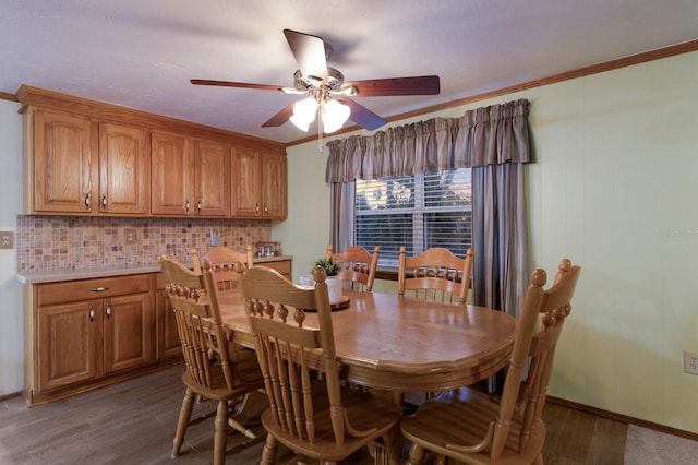 dining room featuring ornamental molding, dark wood-type flooring, and ceiling fan