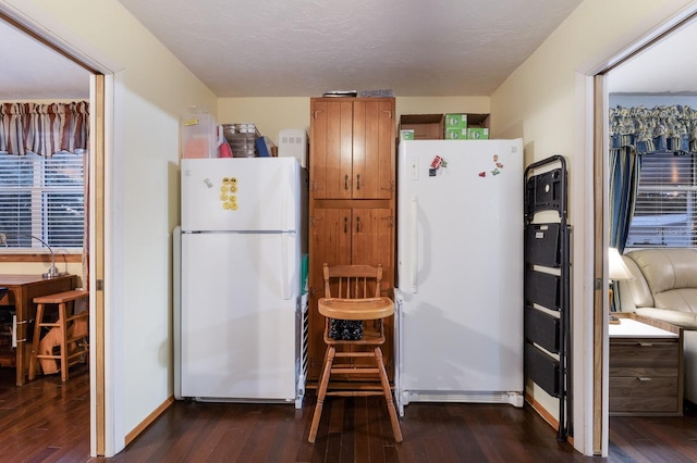 kitchen with dark hardwood / wood-style flooring, white refrigerator, and a textured ceiling