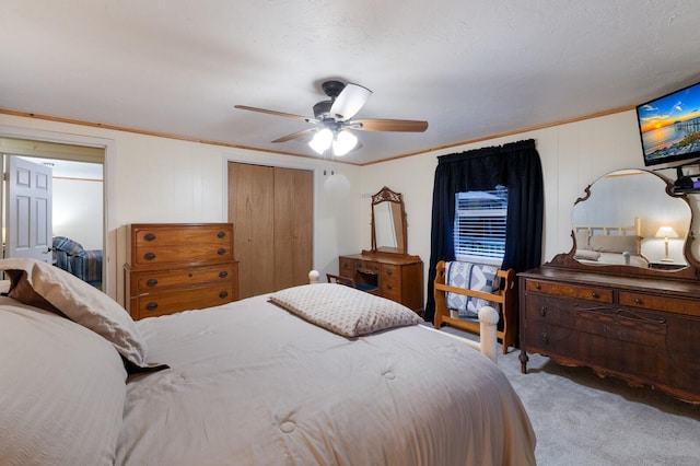 bedroom with a closet, a ceiling fan, carpet flooring, and crown molding