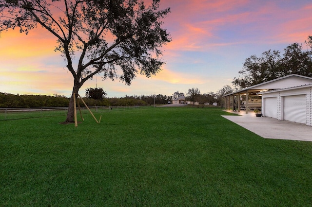 yard at dusk with an outbuilding and a garage