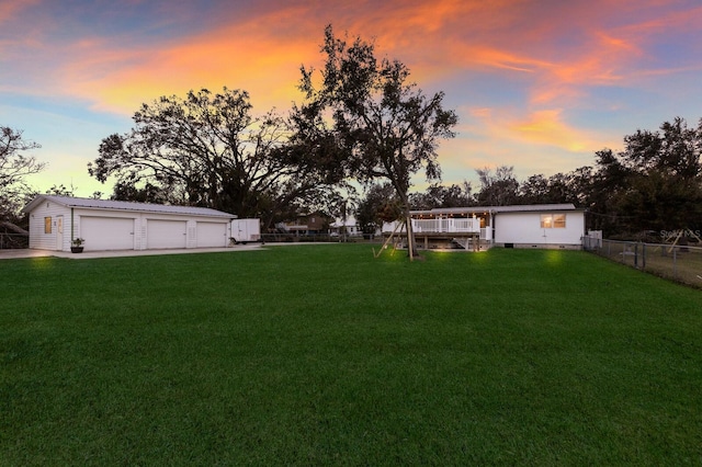 view of yard featuring a detached garage, an outdoor structure, and fence