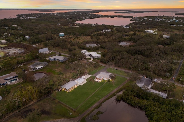 aerial view at dusk featuring a water view