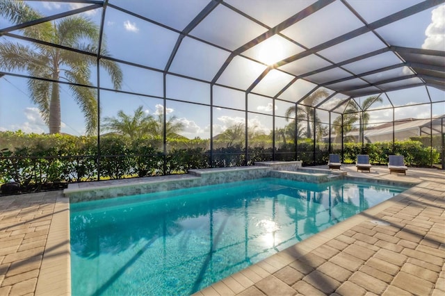 view of pool with glass enclosure and a patio area