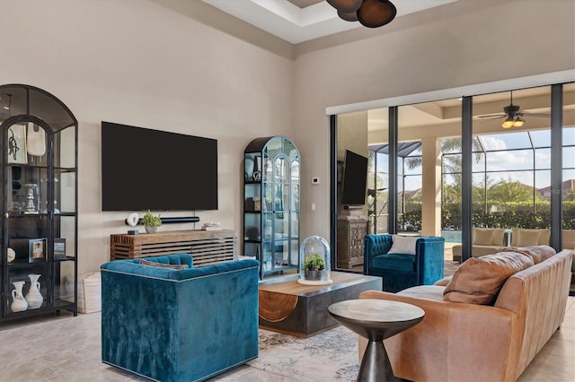 living room with ceiling fan and a towering ceiling