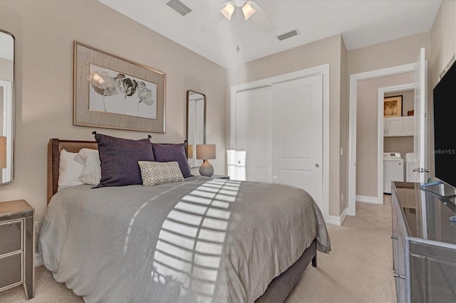 bedroom featuring a closet, independent washer and dryer, light carpet, and ceiling fan