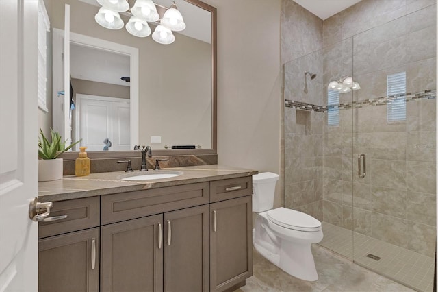 bathroom with toilet, tile patterned flooring, a notable chandelier, vanity, and a shower with shower door