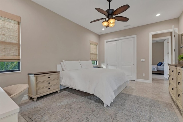 tiled bedroom with ceiling fan and a closet