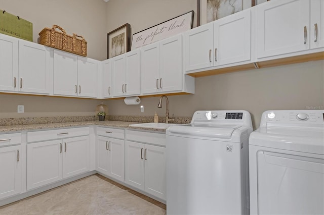 washroom with cabinets, light tile patterned floors, sink, and washing machine and clothes dryer