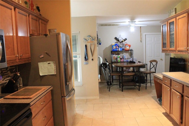 kitchen with stainless steel appliances, ceiling fan, and light tile patterned floors