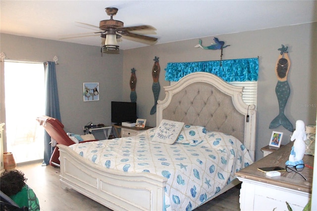 bedroom with ceiling fan, multiple windows, and wood-type flooring