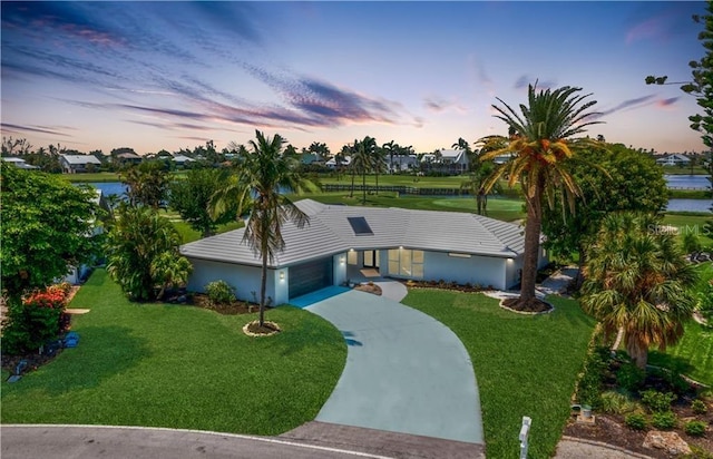 ranch-style house featuring a garage and a lawn