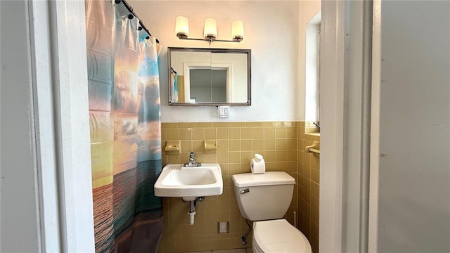 bathroom featuring sink, toilet, and tile walls