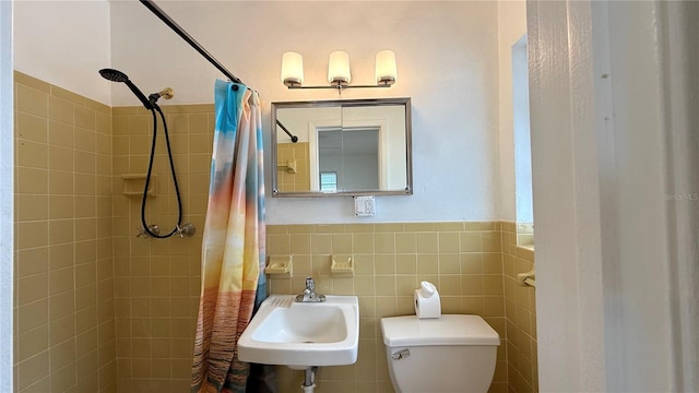 bathroom with walk in shower, tile walls, sink, and toilet