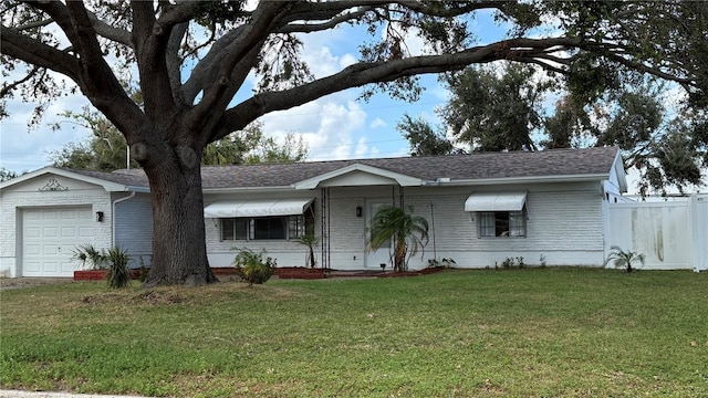 single story home featuring a garage and a front lawn