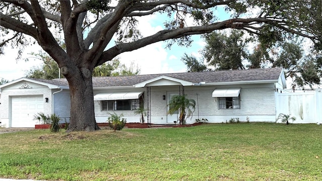 ranch-style home with a garage and a front yard