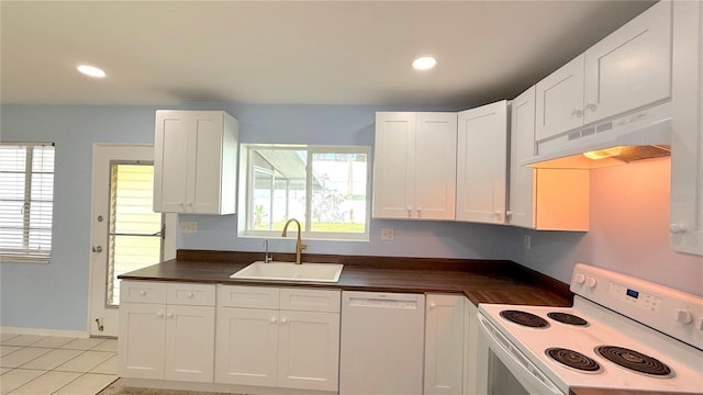 kitchen with light tile patterned flooring, white cabinetry, a wealth of natural light, sink, and white appliances