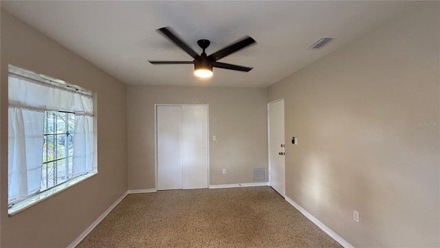 carpeted spare room featuring ceiling fan