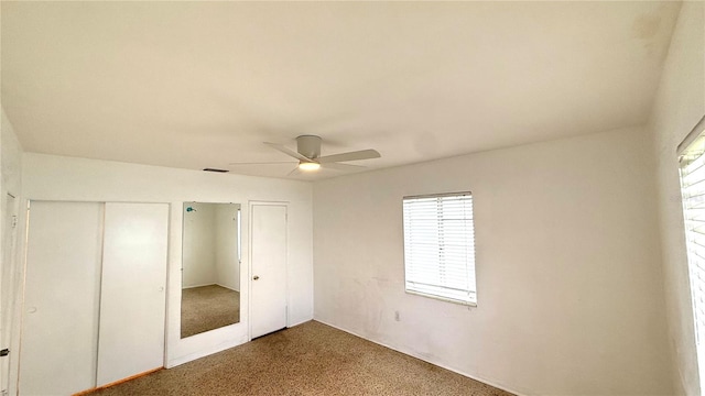 unfurnished bedroom with multiple closets, carpet, and ceiling fan