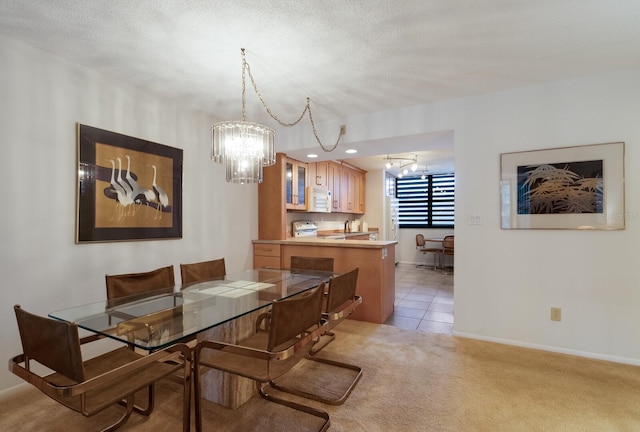 carpeted dining area with a textured ceiling and an inviting chandelier