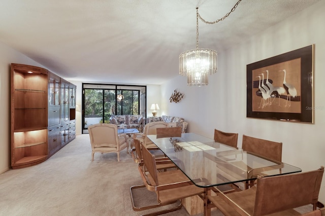 carpeted dining room featuring a textured ceiling and a chandelier