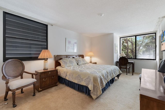 bedroom featuring a textured ceiling and light colored carpet