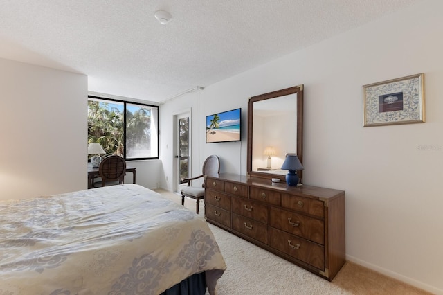 bedroom featuring a textured ceiling and light carpet