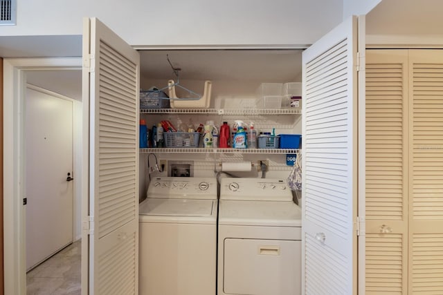 clothes washing area featuring washer and dryer and light tile patterned flooring