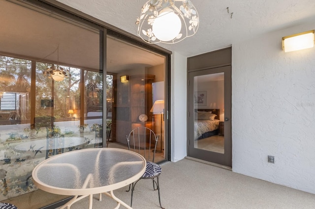 carpeted dining area featuring a textured ceiling