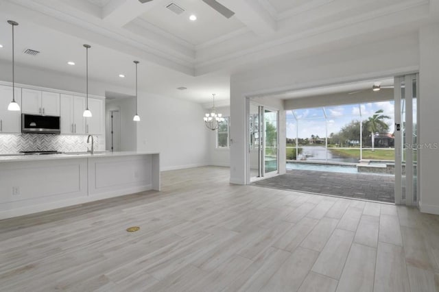 unfurnished living room with light hardwood / wood-style floors, a healthy amount of sunlight, crown molding, and beam ceiling