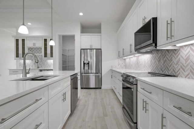 16381 Cape Horn Blvd, Punta Gorda, FL 33955 - kitchen with appliances with stainless steel finishes, a sink, backsplash, white cabinets, and pendant lighting