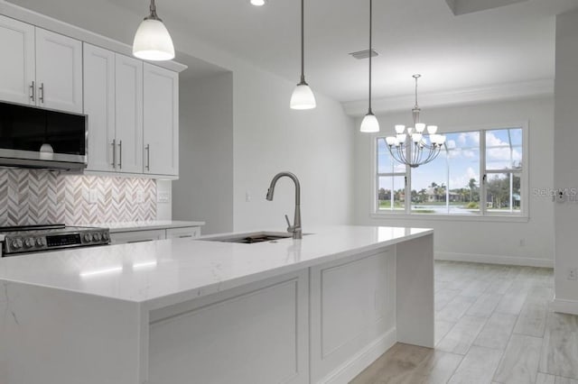 kitchen featuring an inviting chandelier, hanging light fixtures, sink, white cabinetry, and appliances with stainless steel finishes