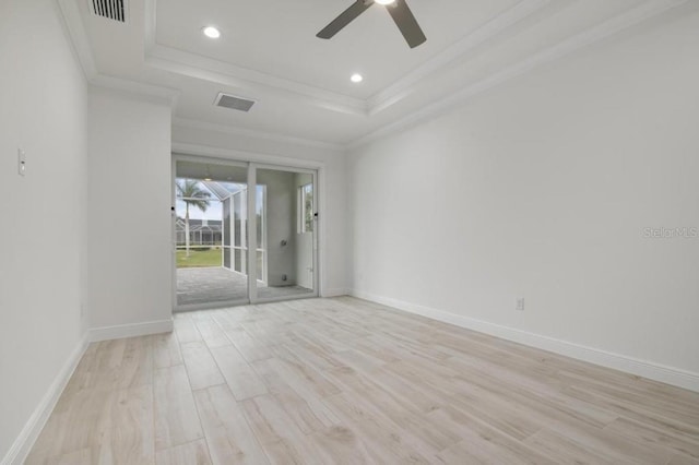 unfurnished room with ceiling fan, light wood-type flooring, crown molding, and a tray ceiling