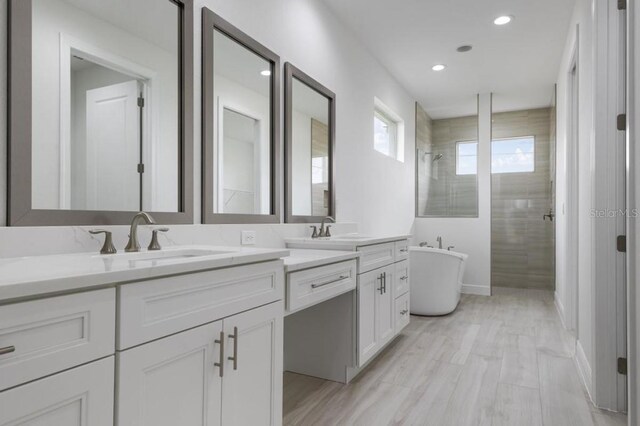 16381 Cape Horn Blvd, Punta Gorda, FL 33955 - full bath with double vanity, a freestanding tub, a tile shower, recessed lighting, and baseboards