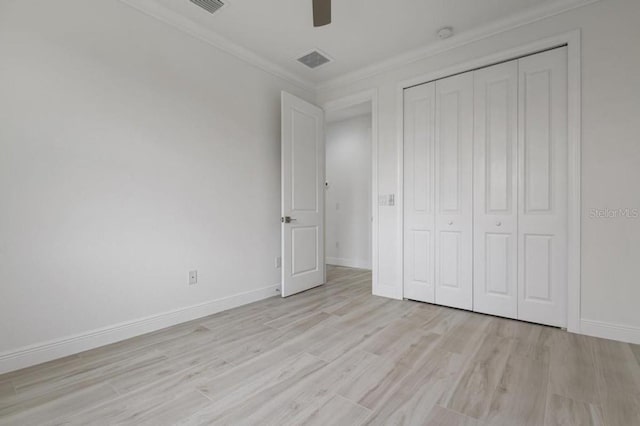 unfurnished bedroom featuring a closet, light hardwood / wood-style floors, ceiling fan, and crown molding