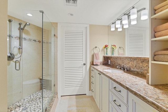 bathroom featuring vanity, tile patterned floors, and a shower with door