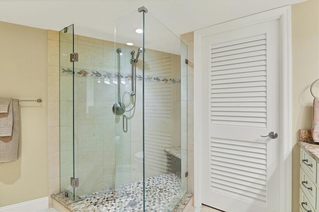 bathroom with a shower with door and vanity