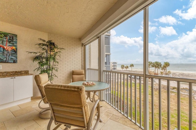 balcony with a water view and a beach view