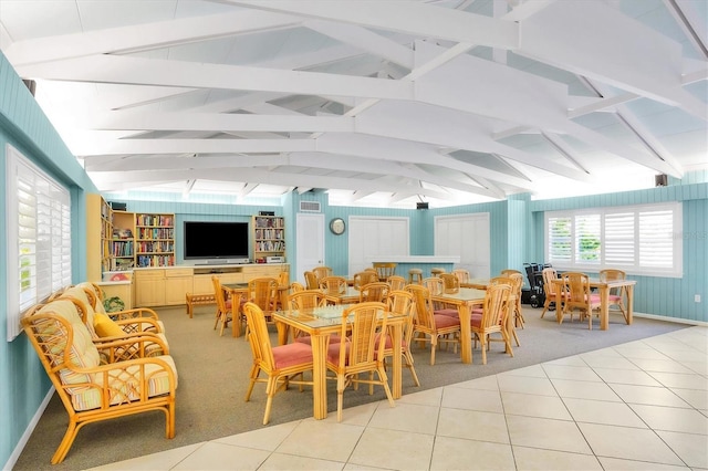 sunroom / solarium featuring vaulted ceiling with beams