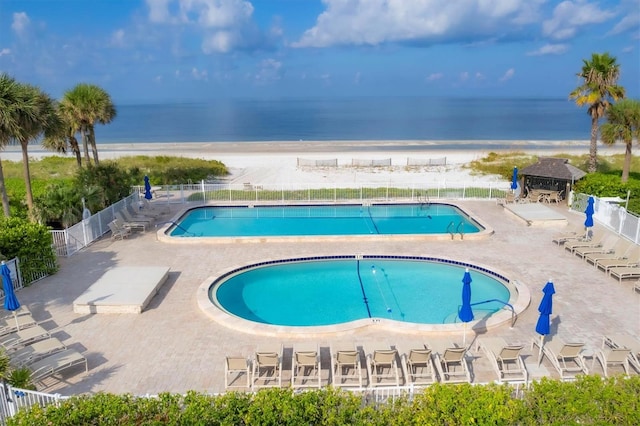 view of swimming pool featuring a water view and a patio area