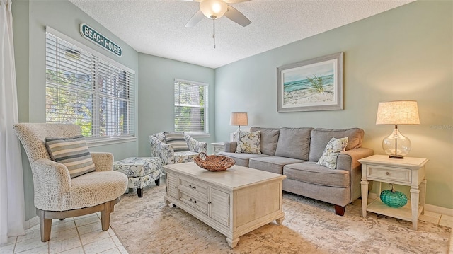 living room featuring light tile patterned flooring, ceiling fan, and a textured ceiling