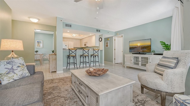 1328 Siesta Bayside Dr Unit 1328-C, Sarasota, FL 34242 - living room with light tile patterned floors, a ceiling fan, and baseboards