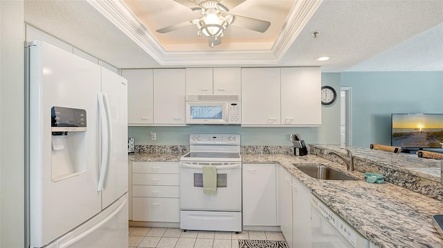 kitchen featuring sink, a textured ceiling, a tray ceiling, white appliances, and white cabinets