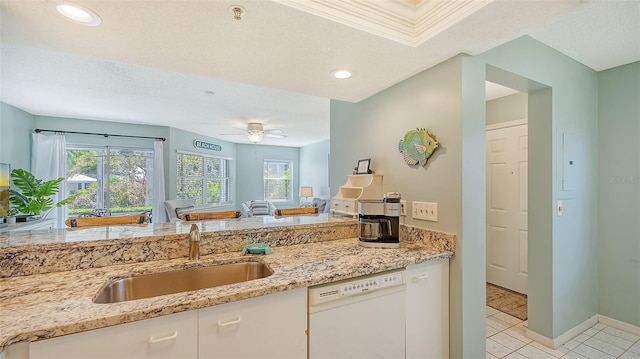 kitchen featuring white cabinetry, sink, white dishwasher, light stone countertops, and ceiling fan