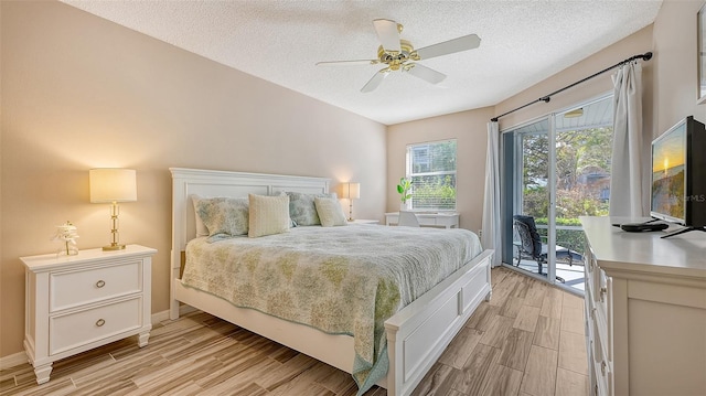 bedroom featuring ceiling fan, light hardwood / wood-style floors, access to exterior, and a textured ceiling