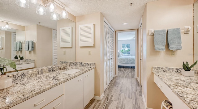 bathroom with wood-type flooring, a textured ceiling, and vanity