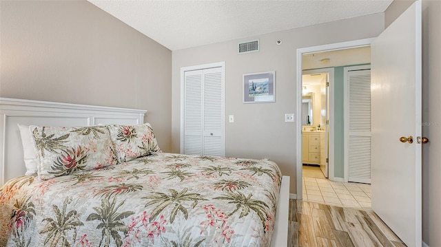 bedroom with light hardwood / wood-style flooring, a textured ceiling, and a closet