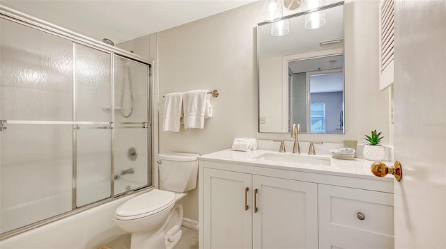 full bathroom with vanity, combined bath / shower with glass door, and toilet