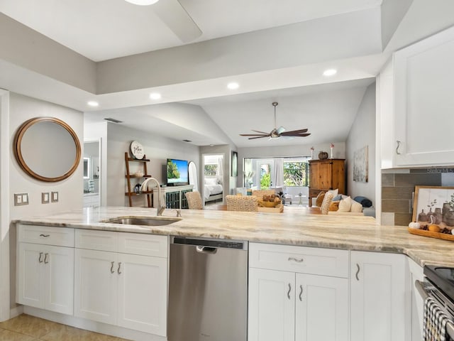 kitchen with sink, kitchen peninsula, appliances with stainless steel finishes, lofted ceiling, and white cabinets