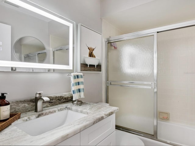 full bathroom with vanity, toilet, and enclosed tub / shower combo