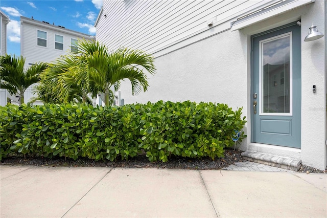 view of exterior entry with a patio